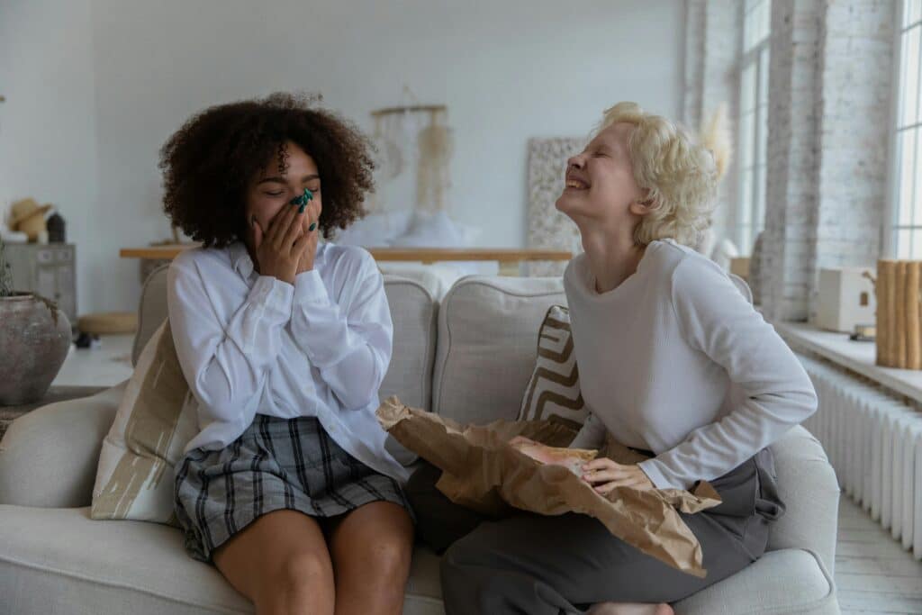 twee vrouwen op de bank lachen - grappen over dikke mensen